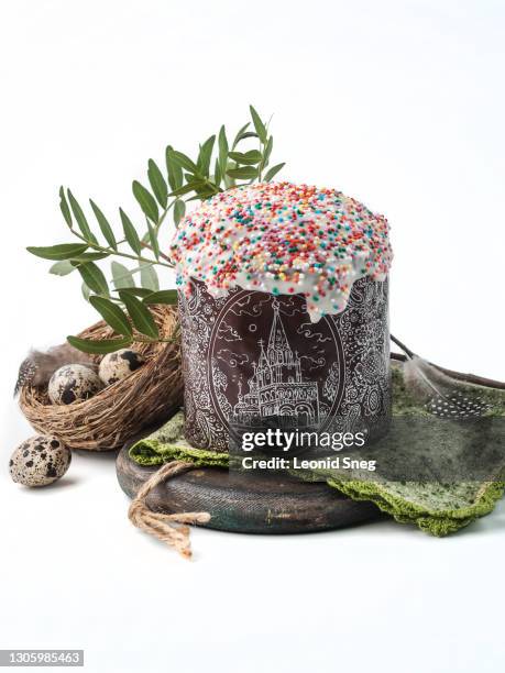 food photography of easter cake in a brown paper mold front view, covered white icing with colored sprinkles closeup on a white background isolated - happy easter in russian stock pictures, royalty-free photos & images