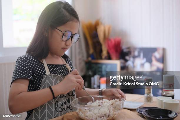 a girl making the rice ball with plastic molds - rice ball stockfoto's en -beelden