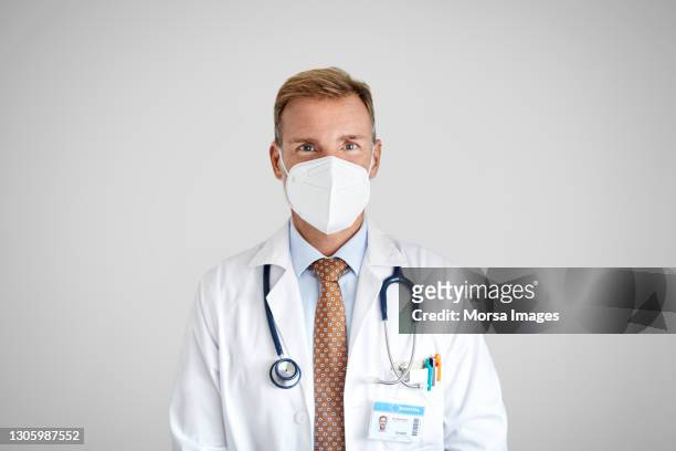 male doctor in face mask during covid-19 - man studio shot stock pictures, royalty-free photos & images