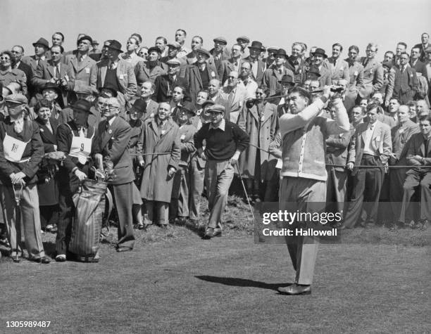 Crowd of spectators watch as Jimmy Bruen of Ireland drives off the 14th tee during the 13th Walker Cup Match golf tournament between the leading...