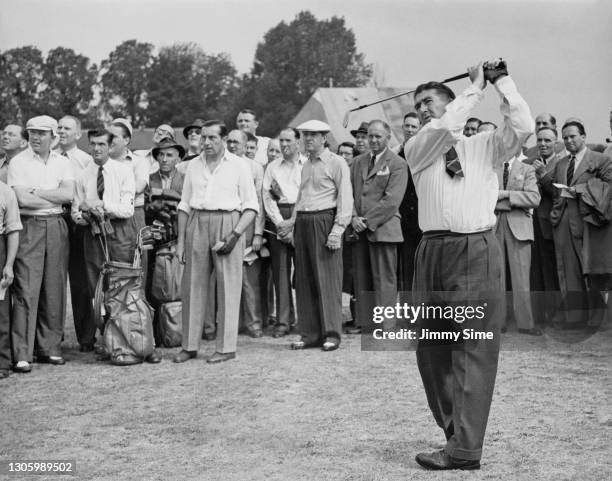 Crowd of spectators and opponent Henry Cotton look on as Jimmy Bruen of Ireland drives off the 1st tee during a practice round for the Great Britain...