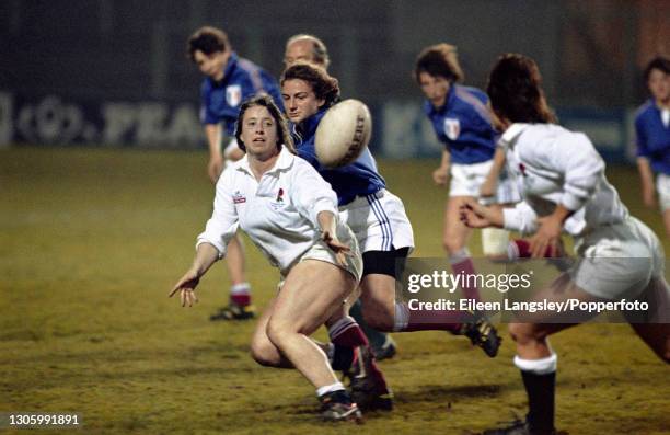 An England player passes the ball to a team mate during play in the semi-final match between England and France in the 1991 Women's Rugby World Cup...