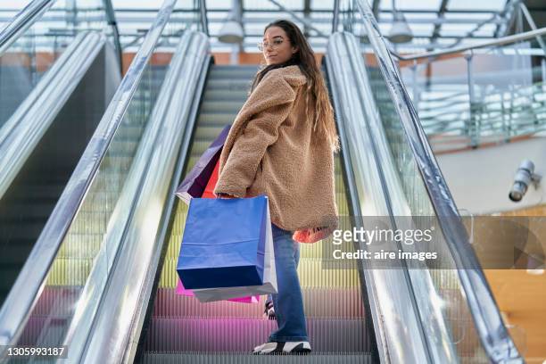 woman holding shopping bags at mall center. - centro commerciale foto e immagini stock