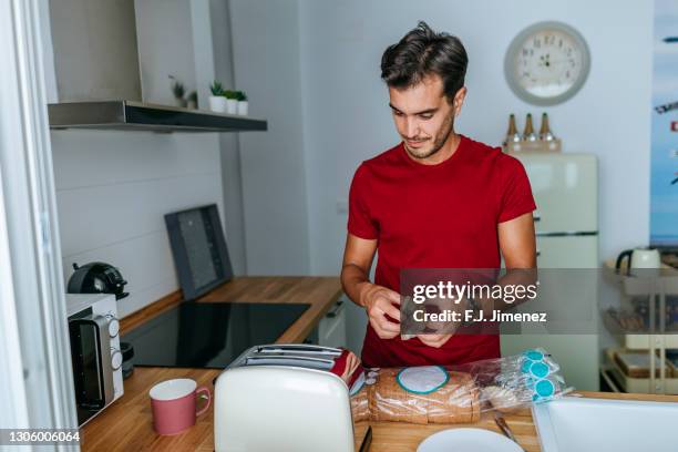 man having breakfast in home kitchen - making sandwich stock pictures, royalty-free photos & images