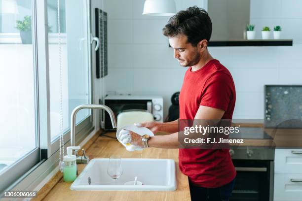 man washing dishes in home kitchen - doing household chores stock pictures, royalty-free photos & images