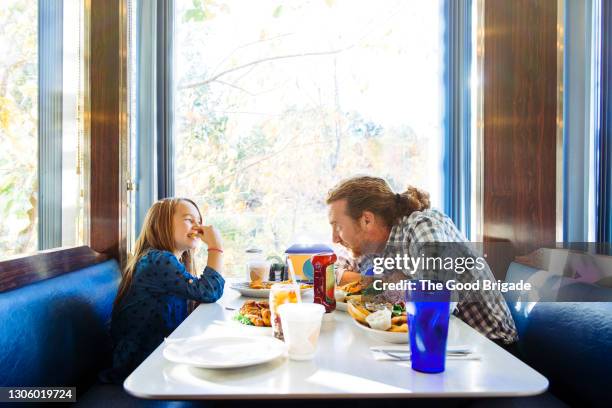 father and daughter eating lunch in a diner - restaurant kids stock-fotos und bilder
