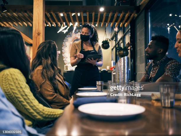 multi ethnic group of friends in an indian restaurant - indian food on table stock pictures, royalty-free photos & images