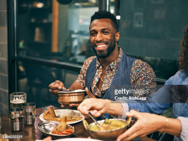 multi ethnic group of friends in an indian restaurant - indian food on table stock pictures, royalty-free photos & images
