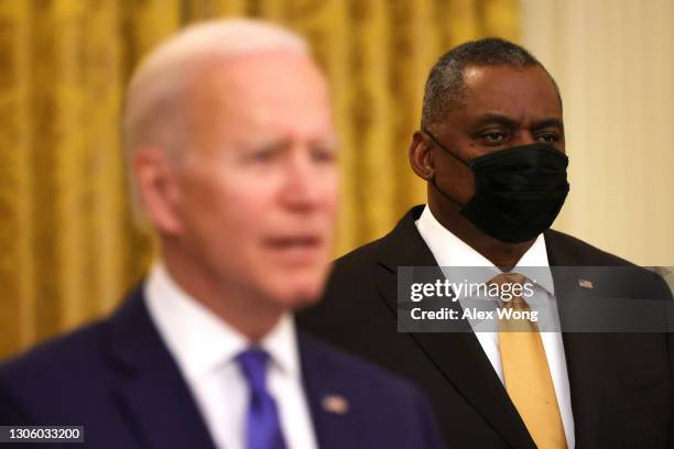 President Joe Biden delivers remarks on International Women’s Day as Secretary of Defense Lloyd Austin listens during an announcement at the East...