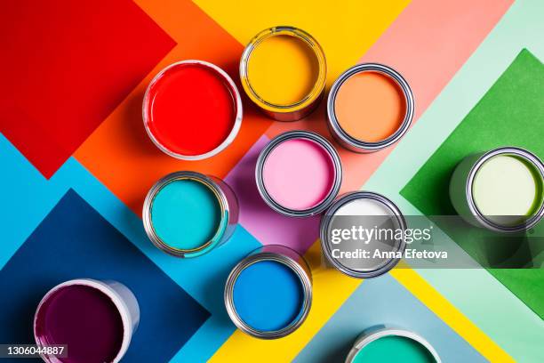 open cans with bright multicolored paints arranged on colorful geometric background divided in several parts representing concept of home repair and renovation supplies. performed in flat lay style. concept of redecoration in home interior. color swatch f - ペンキ缶 ストックフォトと画像