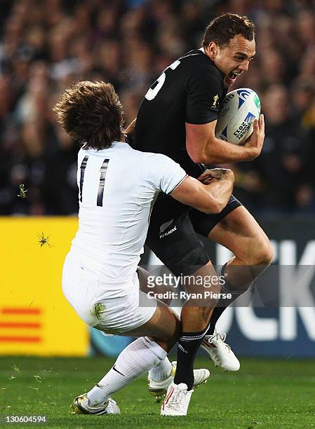 Israel Dagg of the All Blacks is tackled by Alexis Palisson of France during the 2011 IRB Rugby World Cup Final match between France and New Zealand...
