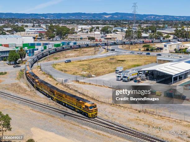 aerial view of loaded grain train passing through industrial district - rail freight stock pictures, royalty-free photos & images