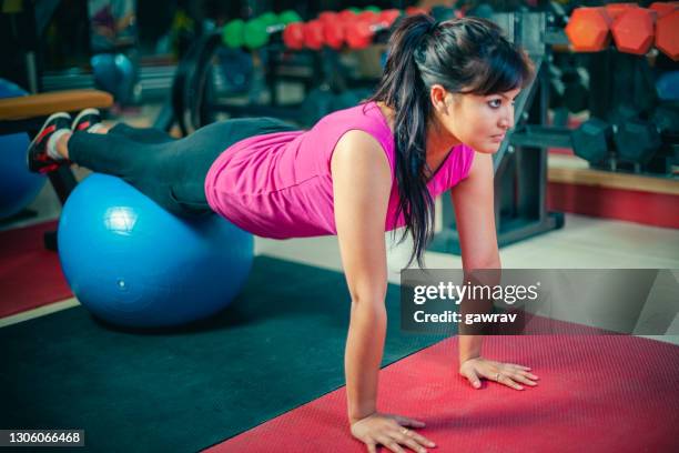 woman does exercise in a gym. - bodyweight training stock pictures, royalty-free photos & images