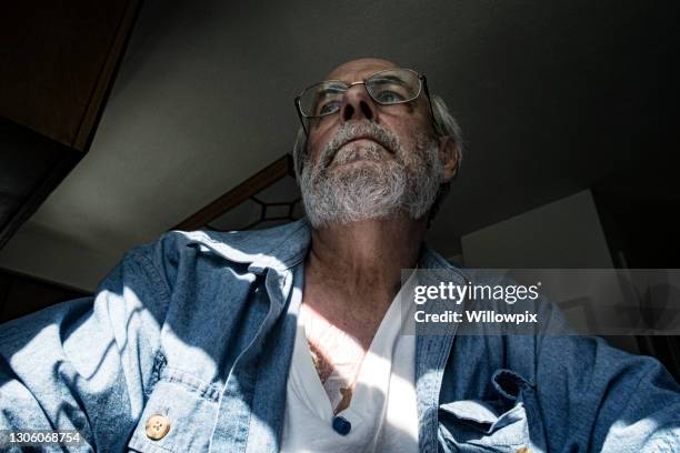 pensive cancer chemotherapy iv patient looking out window - cancer patient portrait stock pictures, royalty-free photos & images