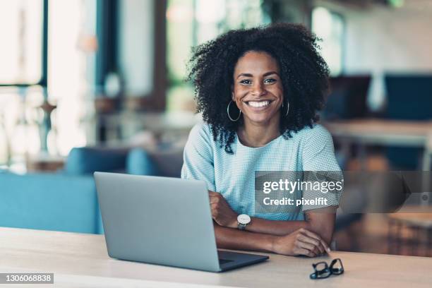 cheerful black businesswoman in an open office - staff wellbeing stock pictures, royalty-free photos & images