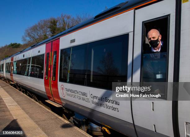 Phillip Airey, a train guard employed by Transport for Wales, peers from the window of his train as it departs the station on February 28, 2021 in...