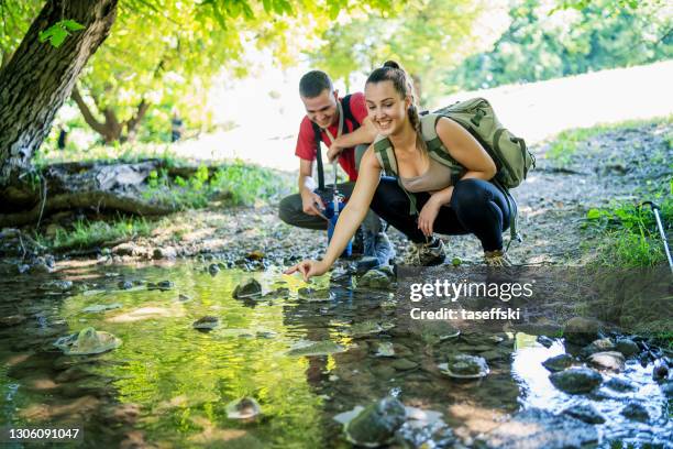 frau wäscht hände im gebirgsbach - hand resting on wood stock-fotos und bilder