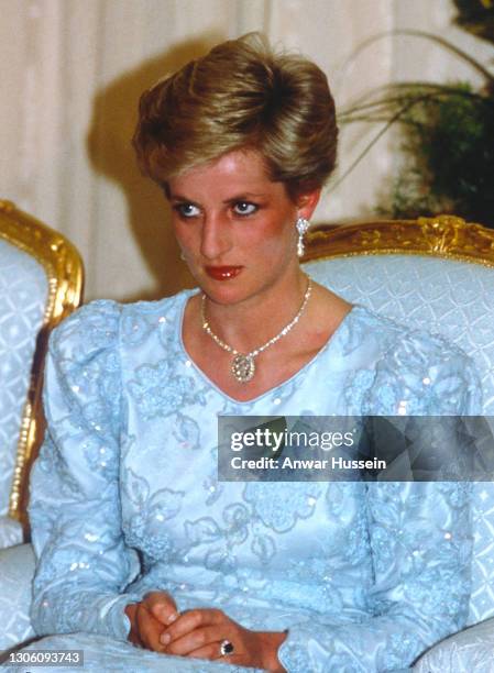 Diana, Princess of Wales, wearing a blue chiffon and lace dress with sequins designed by Catherine Walker and diamond and pearl drop earrings,...