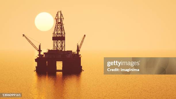 offshore booreiland bij zonsondergang - boortoren stockfoto's en -beelden