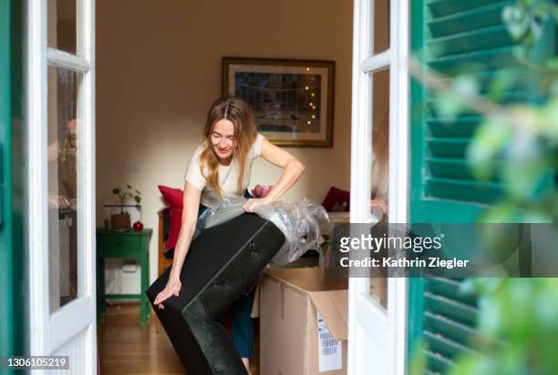woman unwrapping a new piece of furniture - answering door stock pictures, royalty-free photos & images