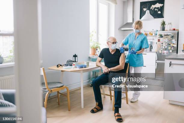 homme aîné obtenant le vaccin tiré à la maison - clothing shot flat photos et images de collection