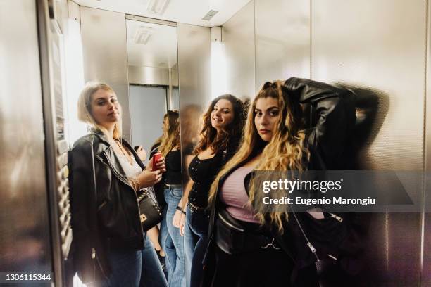three young women in elevator - plus size fashion stock pictures, royalty-free photos & images