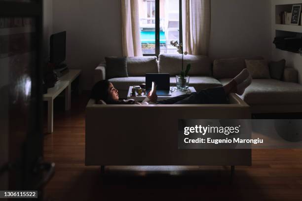 young woman on sofa with mobile phone - feet on table stock pictures, royalty-free photos & images