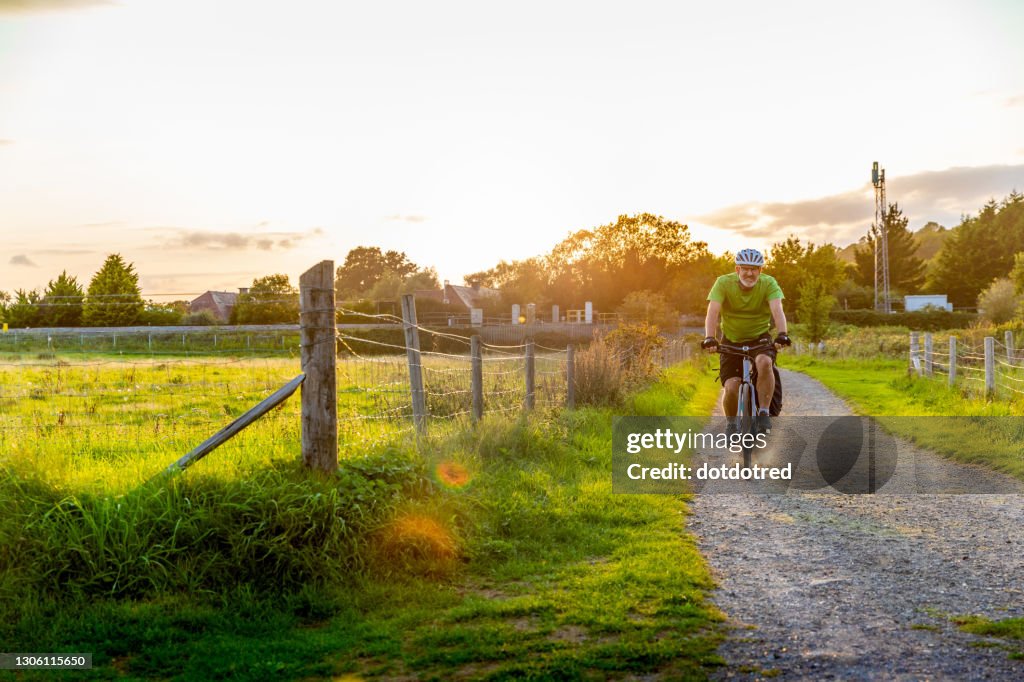 Man mountain biking on rural path