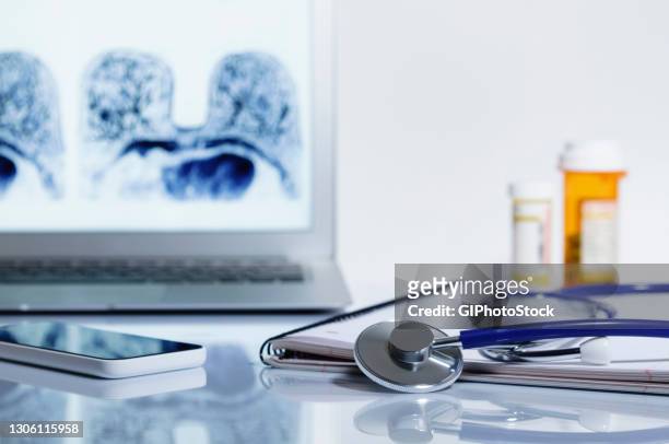 acoustic stethoscope and laptop displaying mri image - seno foto e immagini stock