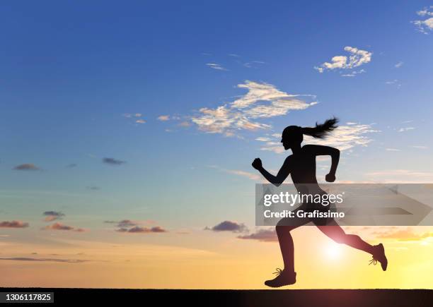 vrouwelijke atleet die bij zonsondergang loopt - woman running silhouette stockfoto's en -beelden