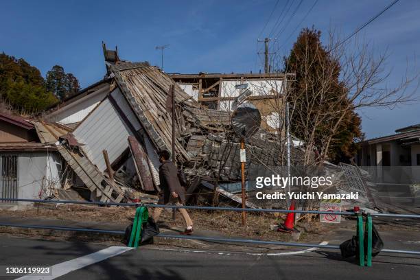 Man walk pass a collapsed house on March 09, 2021 in Futaba, Japan. In ceremonies that are expected to be scaled back because of the Covid-19...