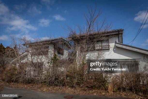 Weeds and vines grow around abandoned houses inside exclusion zone on March 09, 2021 in Okuma, Japan. In ceremonies that are expected to be scaled...