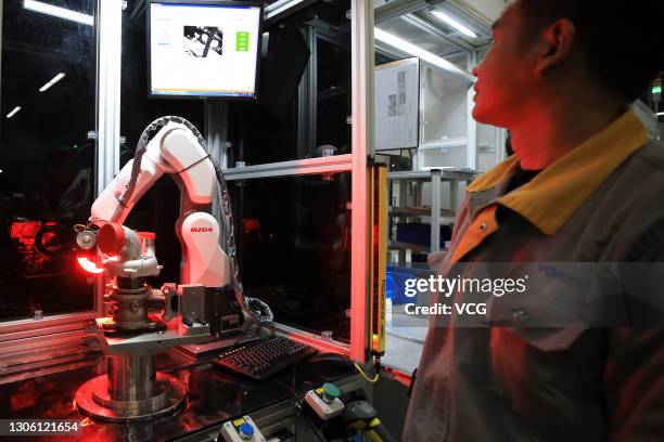 An employee works on the assembly line of turbochargers for automobiles at a factory of Vofon Turbo System Co., Ltd on March 9, 2021 in Jiaxing,...