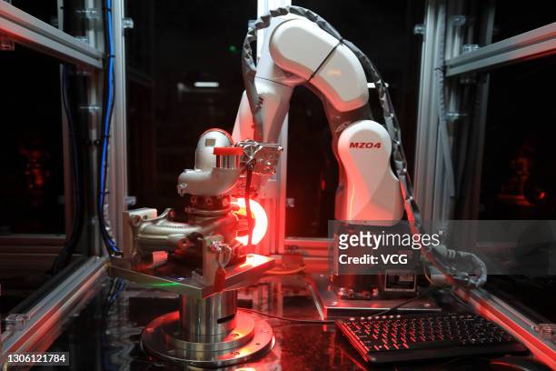 Robotic arm works on the assembly line of turbochargers for automobiles at a factory of Vofon Turbo System Co., Ltd on March 9, 2021 in Jiaxing,...