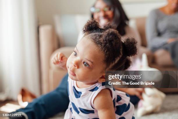 cute baby girl with mother sitting in living room - engatinhando - fotografias e filmes do acervo