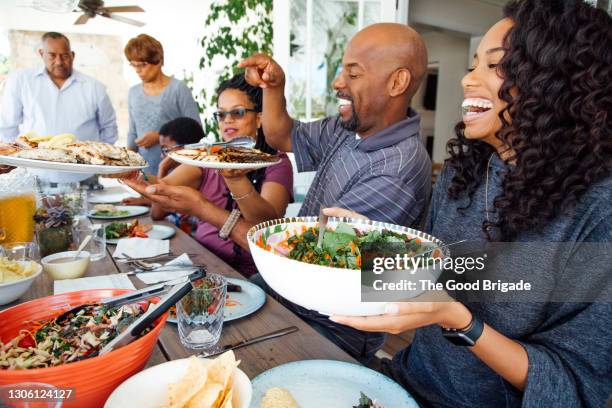 multigenerational family enjoy meal together on patio - family reunion stock pictures, royalty-free photos & images