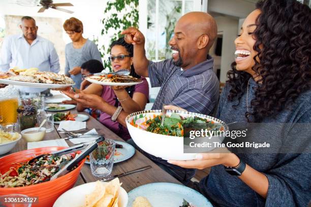 multigenerational family enjoy meal together on patio - salladsskål bildbanksfoton och bilder