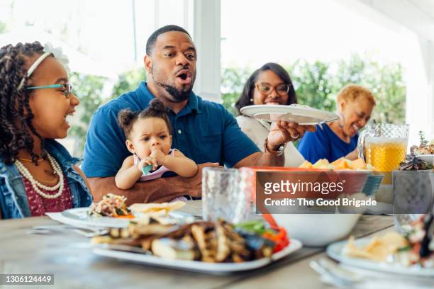 cheerful family eating at table in backyard - black family reunion stock pictures, royalty-free photos & images