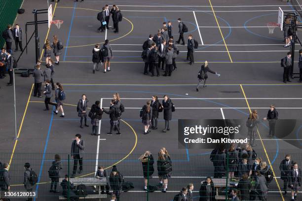 Pupils gather in the playground ahead of their first day back from lockdown at Chertsey High School on March 09, 2021 in Chertsey, United Kingdom....