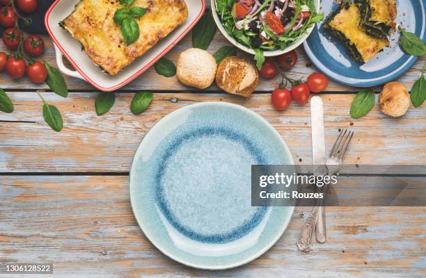 eettafel met voedsel en leeg bord - blue bowl stockfoto's en -beelden
