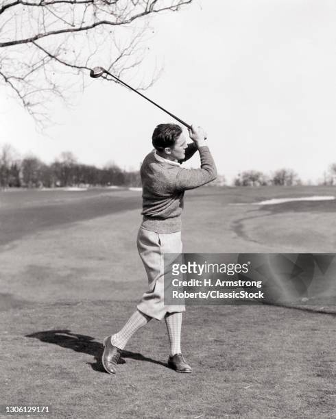 1920s 1930s Man Golfer Full swing Teeing Off Wearing sweater Plus Fours.