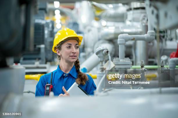 female service engineer are checking the system in boiler room and holding digital tablet at a factory. the hvac ( heating, ventilation and air conditioning ) control systems. - boiler engineer stockfoto's en -beelden