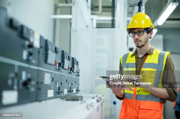 solar inverter control room system and battery storage.  electrician engineer monitoring of solar charge controller and record data to mobile app on digital tablet. - fornitura di energia foto e immagini stock