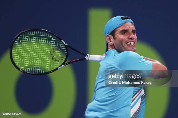 Malek Jaziri of Tunisia plays a forehand in his Round One match against Norbert Gombos of Slovakia during Day Two of the Qatar ExxonMobil Open 2021...