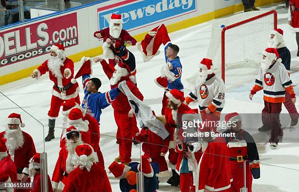 New York Ranger fans dressed as Santa Claus mock the Islanders fans in the first period intermission during the Philadelphia Flyers and New York...