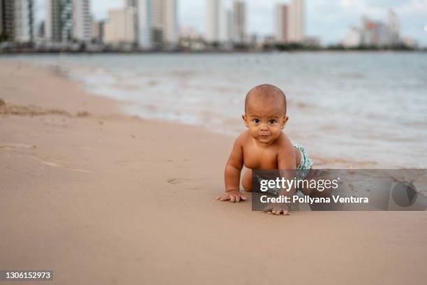 bebé arrastrándose en la orilla - baby crawling on sand fotografías e imágenes de stock