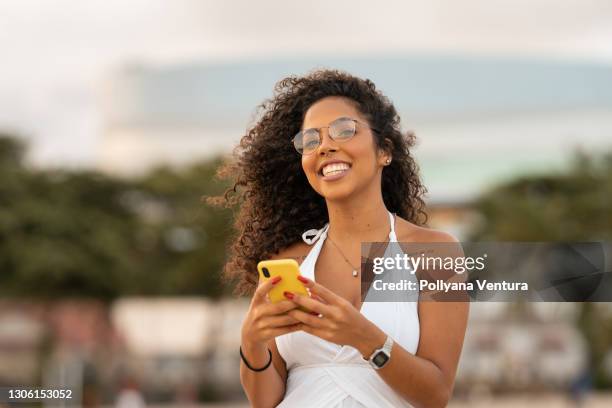 happy woman using smart phone on the beach - cell phone using beach stock pictures, royalty-free photos & images
