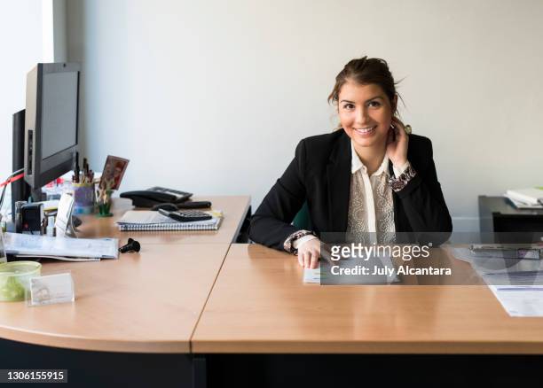 pretty woman in her desk looking at camera. office worker - bank office clerks stock pictures, royalty-free photos & images