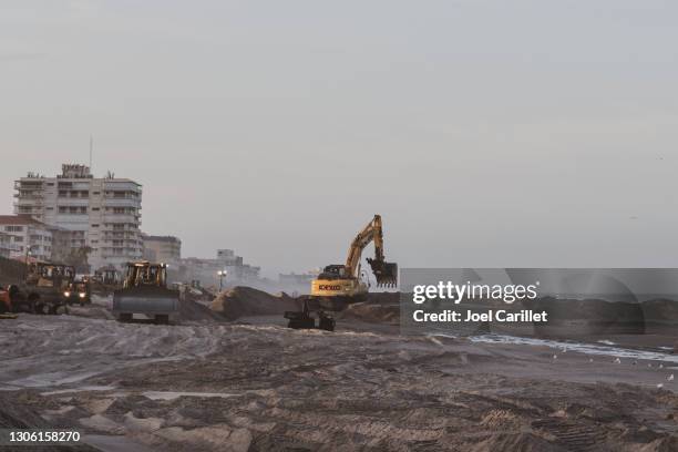 美國佛羅里達州印度蘭蒂奇 - 2021年2月11日：地球移動設備，包括推土機和挖掘機，在佛羅里達州佈雷瓦德縣的海灘填海工程中工作，分配從近海抽來的沙子。 - erosion 個照片及圖片檔