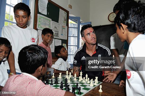 Kevin Pietersen of England plays chess with youngsters during a team visit to Future Hope School on October 27, 2011 in Kolkata, India. The England...